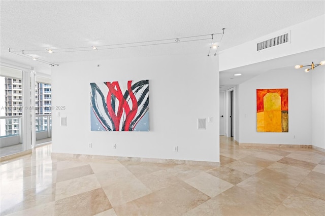 21055 Yacht Club Dr Unit 2104, Aventura, FL 33180 - empty room featuring rail lighting, a textured ceiling, and light tile patterned floors