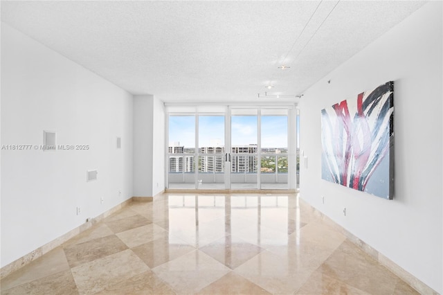 21055 Yacht Club Dr Unit 2104, Aventura, FL 33180 - unfurnished room featuring a textured ceiling, light tile patterned floors, expansive windows, and baseboards