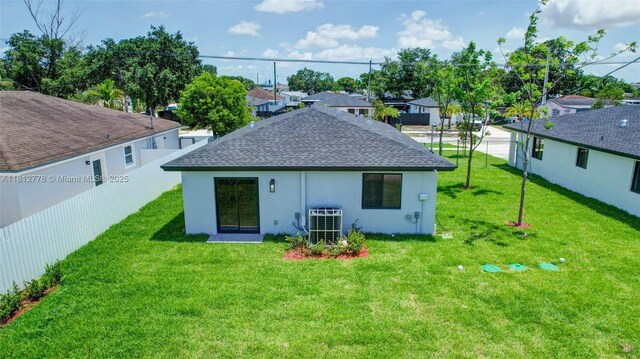 2411 NW 153rd St, Miami Gardens, FL 33054 - rear view of property featuring a shingled roof, a yard, central AC, and stucco siding