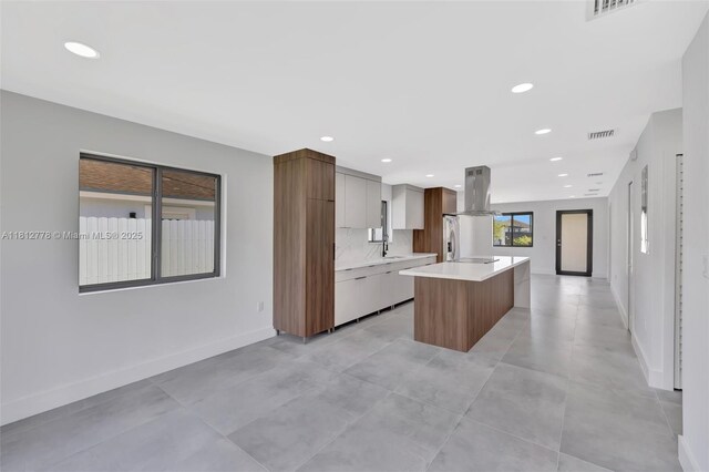 2411 NW 153rd St, Miami Gardens, FL 33054 - kitchen with modern cabinets, island range hood, light countertops, a center island, and baseboards