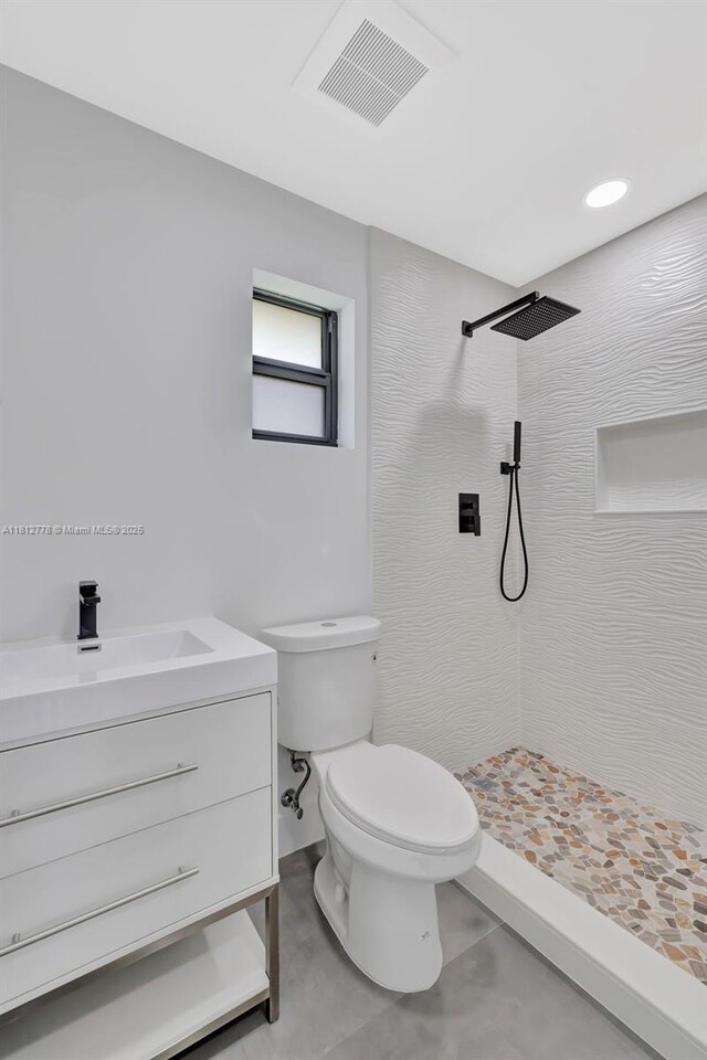 2411 NW 153rd St, Miami Gardens, FL 33054 - bathroom with tiled shower, toilet, vanity, and tile patterned flooring