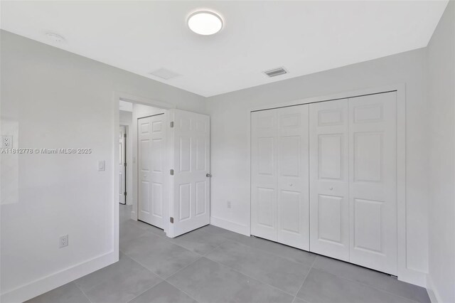 2411 NW 153rd St, Miami Gardens, FL 33054 - unfurnished bedroom featuring baseboards, light tile patterned floors, and a closet