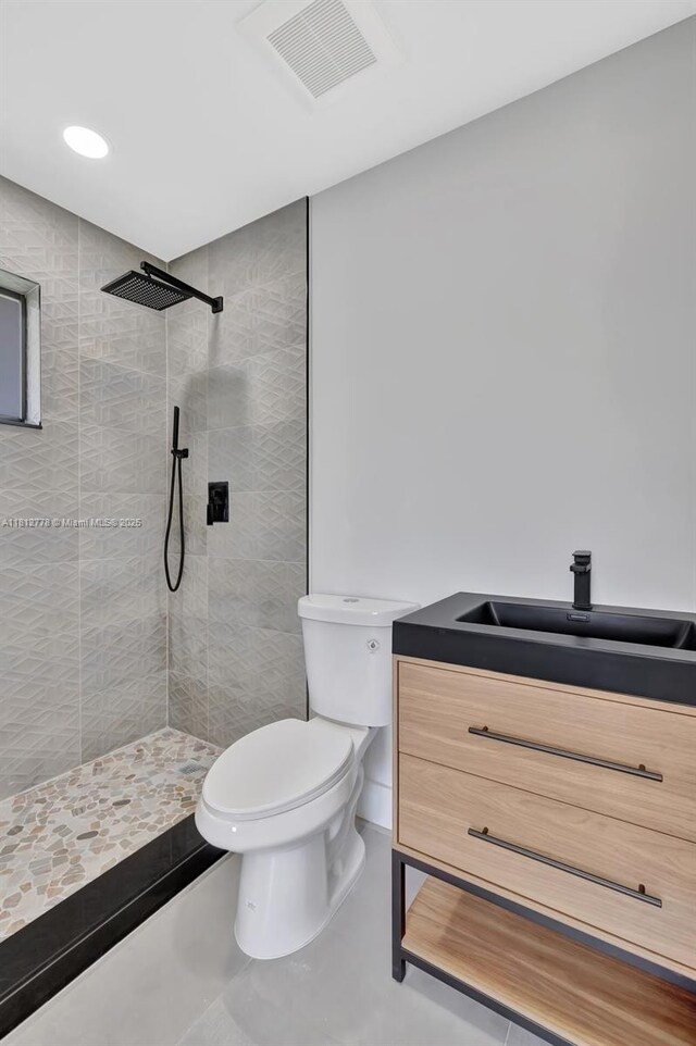 2411 NW 153rd St, Miami Gardens, FL 33054 - full bath with toilet, a tile shower, vanity, concrete floors, and recessed lighting