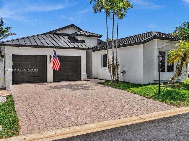 13381 SW 151st Ter, Miami, FL 33186 - view of front of home with stucco siding, a standing seam roof, an attached garage, driveway, and metal roof