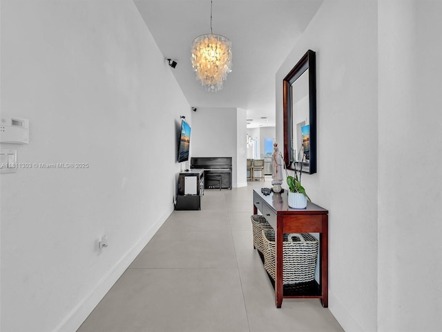 13381 SW 151st Ter, Miami, FL 33186 - hallway featuring a chandelier, baseboards, and concrete floors