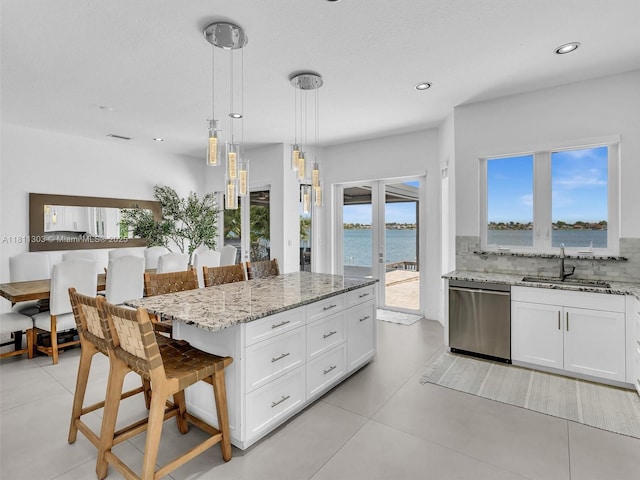 13381 SW 151st Ter, Miami, FL 33186 - kitchen with stainless steel dishwasher, a sink, tasteful backsplash, a breakfast bar area, and light stone counters