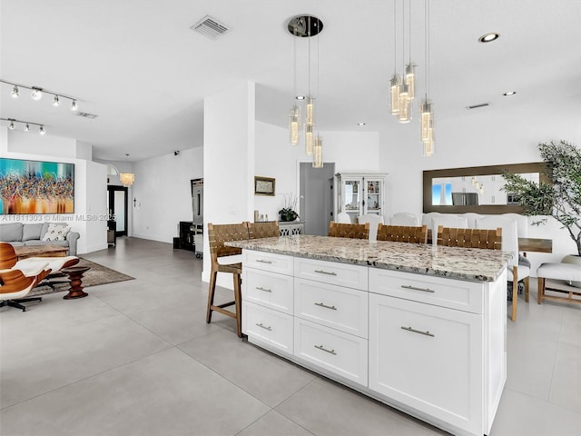 13381 SW 151st Ter, Miami, FL 33186 - kitchen with open floor plan, white cabinets, light stone counters, hanging light fixtures, and a center island