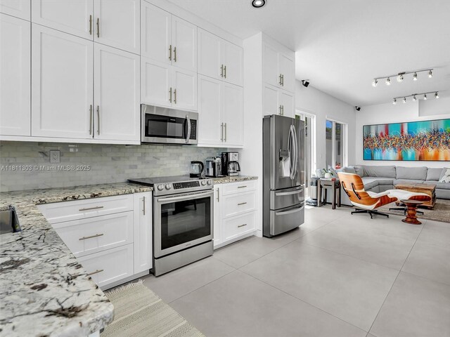 13381 SW 151st Ter, Miami, FL 33186 - kitchen featuring stainless steel appliances, open floor plan, backsplash, white cabinetry, and light stone counters