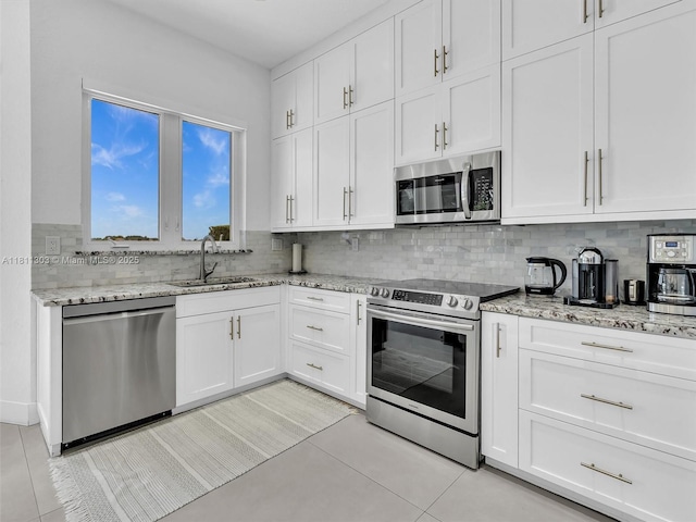 13381 SW 151st Ter, Miami, FL 33186 - kitchen with appliances with stainless steel finishes, a sink, decorative backsplash, white cabinets, and light tile patterned floors