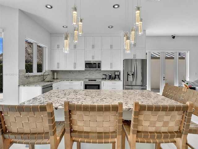 13381 SW 151st Ter, Miami, FL 33186 - kitchen featuring appliances with stainless steel finishes, a sink, decorative backsplash, white cabinetry, and light stone countertops