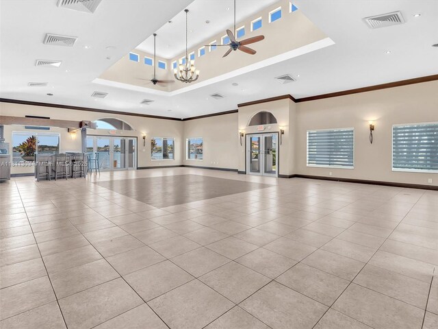 13381 SW 151st Ter, Miami, FL 33186 - unfurnished living room with a tray ceiling, ceiling fan, tile patterned floors, crown molding, and plenty of natural light