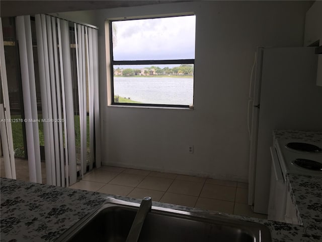 1061 Jefferson Dr Unit 1061B, Homestead, FL 33034 - kitchen featuring light tile patterned floors, a water view, range, and light stone counters
