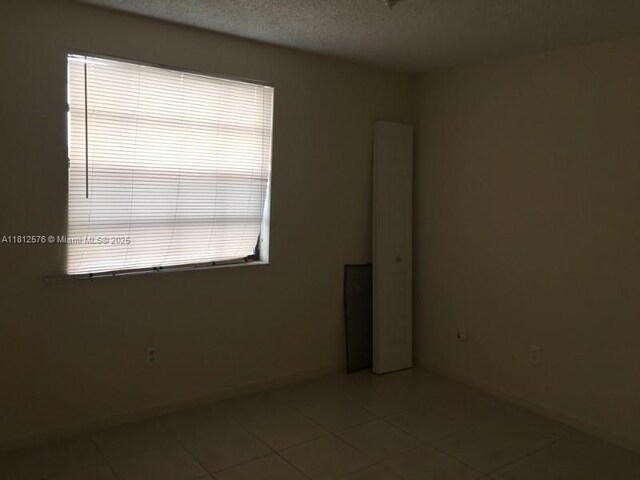 1061 Jefferson Dr Unit 1061B, Homestead, FL 33034 - tiled spare room featuring baseboards and a textured ceiling