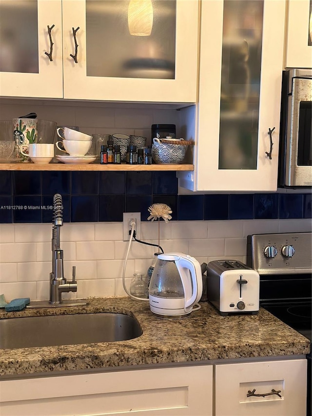 1130 11th St Unit 6H, Miami Beach, FL 33139 - kitchen view of a sink, electric stove, decorative backsplash, and stainless steel microwave