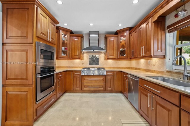 991 Dove Ave, Miami Springs, FL 33166 - kitchen featuring stainless steel appliances, wall chimney range hood, a sink, brown cabinets, and recessed lighting