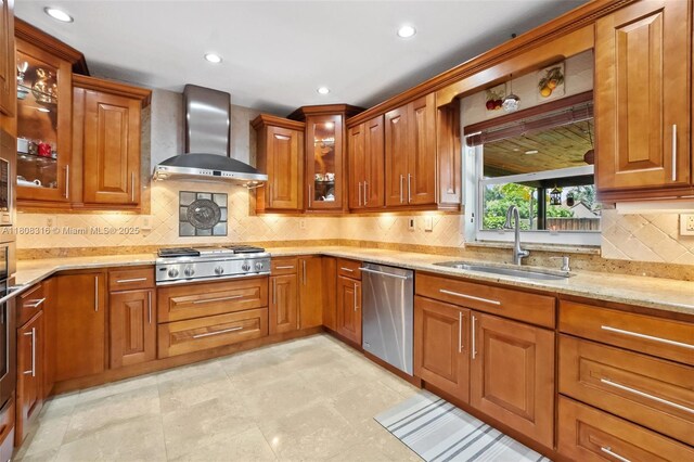 991 Dove Ave, Miami Springs, FL 33166 - kitchen featuring wall chimney range hood, stainless steel appliances, a sink, light stone countertops, and brown cabinets