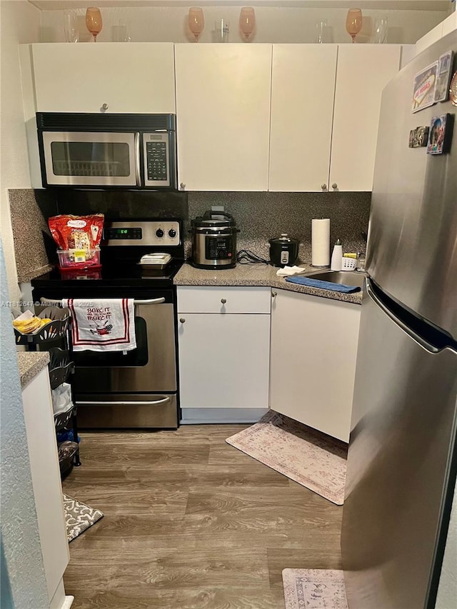 17255 SW 95th Ave Unit D-349, Palmetto Bay, FL 33157 - kitchen featuring stainless steel appliances, white cabinetry, light countertops, and light wood-style flooring