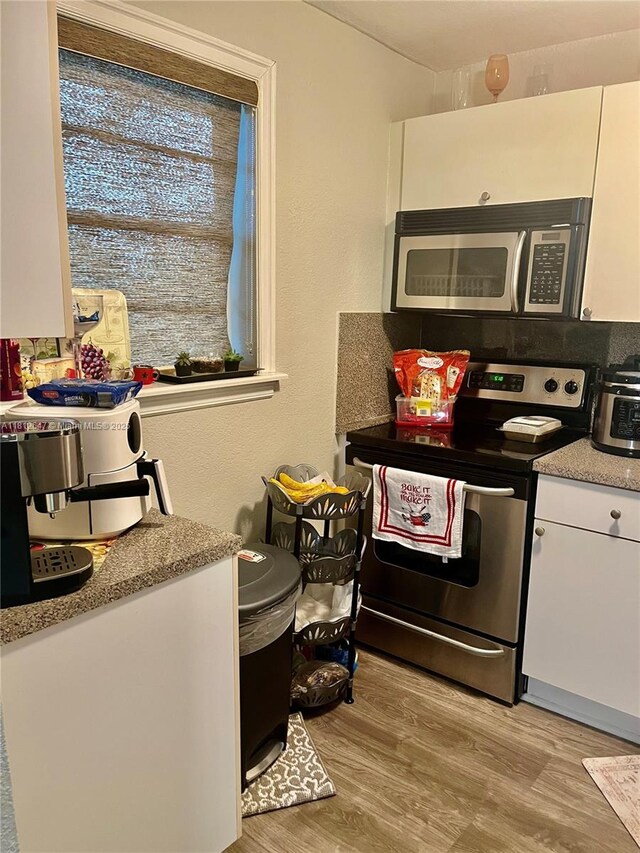 17255 SW 95th Ave Unit D-349, Palmetto Bay, FL 33157 - kitchen featuring appliances with stainless steel finishes, white cabinets, light wood-style flooring, and light countertops