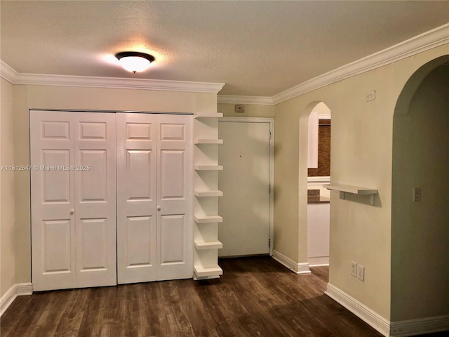 17255 SW 95th Ave Unit D-349, Palmetto Bay, FL 33157 - unfurnished bedroom featuring arched walkways, dark wood finished floors, ornamental molding, a closet, and a textured ceiling