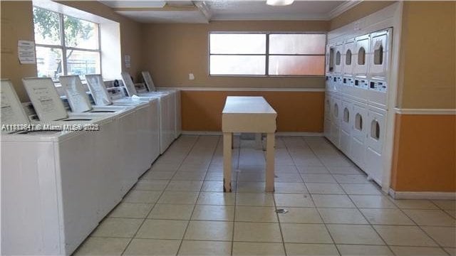 17255 SW 95th Ave Unit D-349, Palmetto Bay, FL 33157 - community laundry room featuring stacked washing machine and dryer, washing machine and clothes dryer, healthy amount of natural light, baseboards, and crown molding