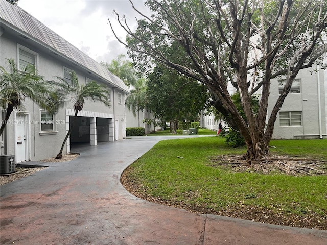 17255 SW 95th Ave Unit D-349, Palmetto Bay, FL 33157 - view of grassy yard featuring concrete driveway and an attached garage