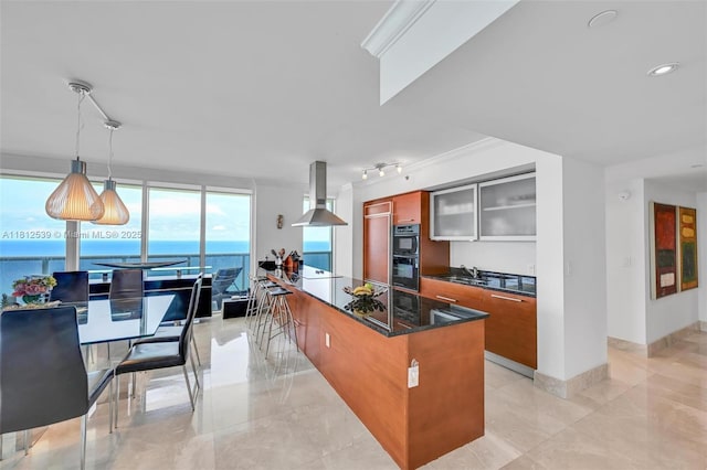 1830 S Ocean Dr Unit 3801, Hallandale Beach, FL 33009 - kitchen featuring exhaust hood, brown cabinetry, modern cabinets, glass insert cabinets, and decorative light fixtures