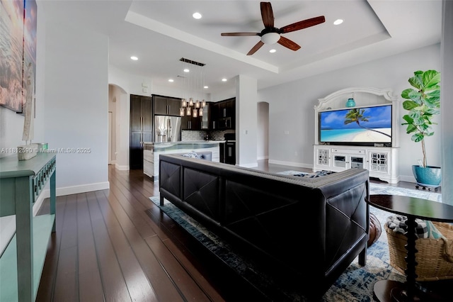 2046 SE 18th St, Homestead, FL 33035 - living area with arched walkways, a raised ceiling, a ceiling fan, dark wood-type flooring, and baseboards