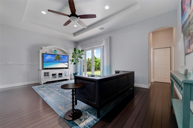 2046 SE 18th St, Homestead, FL 33035 - living room featuring a tray ceiling, arched walkways, baseboards, ceiling fan, and recessed lighting