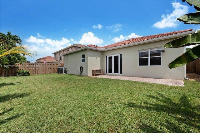 2046 SE 18th St, Homestead, FL 33035 - back of house featuring french doors, stucco siding, a tile roof, central AC, and a patio