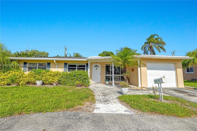 4051 NE 17th Ter, Pompano Beach, FL 33064 - ranch-style house featuring a garage, stucco siding, and asphalt driveway