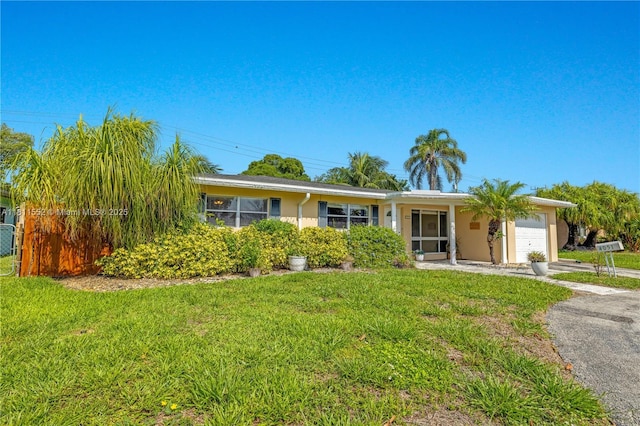 4051 NE 17th Ter, Pompano Beach, FL 33064 - ranch-style home with an attached garage, driveway, a front lawn, and stucco siding