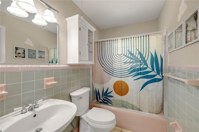 4051 NE 17th Ter, Pompano Beach, FL 33064 - full bathroom featuring tile walls, shower / bath combo with shower curtain, toilet, a sink, and a wainscoted wall