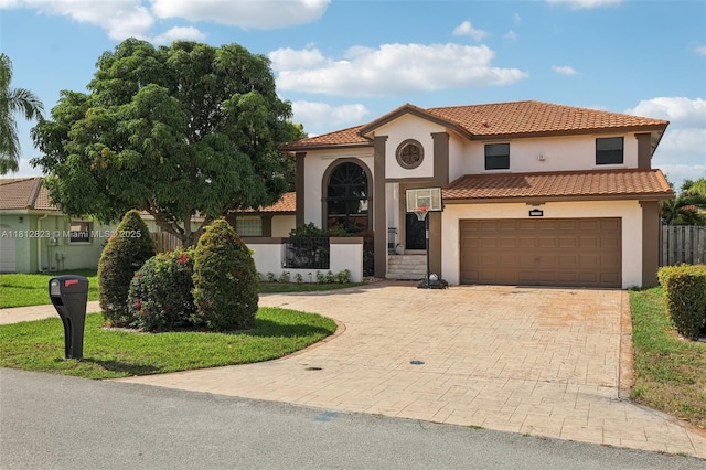 15050 E Falcons Lea Dr, Davie, FL 33331 - mediterranean / spanish-style house with stucco siding, an attached garage, decorative driveway, and a tiled roof