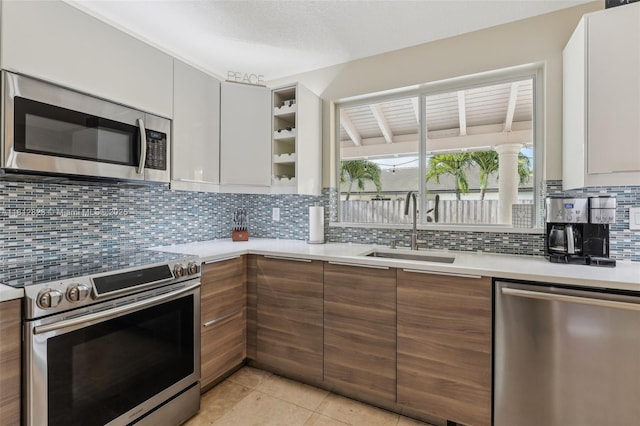 15050 E Falcons Lea Dr, Davie, FL 33331 - kitchen featuring stainless steel appliances, a sink, light countertops, modern cabinets, and decorative backsplash