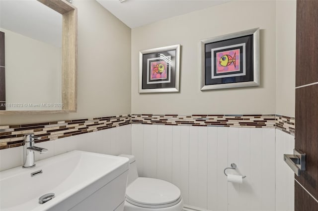 15050 E Falcons Lea Dr, Davie, FL 33331 - bathroom with toilet, vanity, a wainscoted wall, and tile walls
