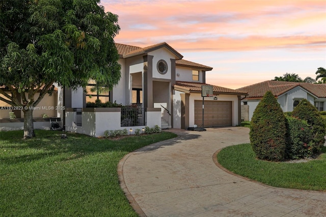15050 E Falcons Lea Dr, Davie, FL 33331 - mediterranean / spanish-style home with a tiled roof, decorative driveway, stucco siding, a yard, and a garage