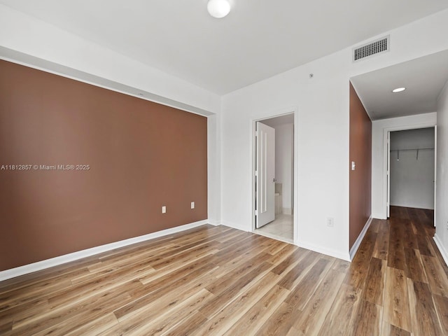 253 NE 2nd St Unit 3108, Miami, FL 33132 - unfurnished bedroom featuring wood finished floors, connected bathroom, baseboards, and a closet