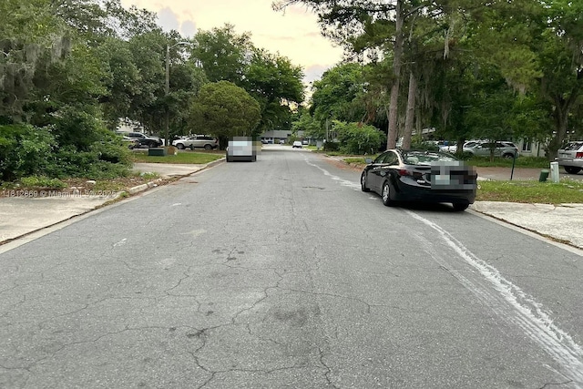 2927 SW 39th Ave, Gainesville, FL 32608 - view of asphalt street with curbs, street lighting, and view of scattered trees