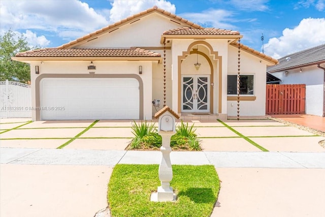 8902 NW 148th St, Miami Lakes, FL 33018 - mediterranean / spanish-style house with driveway, stucco siding, an attached garage, and a tiled roof