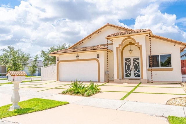 8902 NW 148th St, Miami Lakes, FL 33018 - mediterranean / spanish-style house with a tiled roof, stucco siding, an attached garage, and driveway