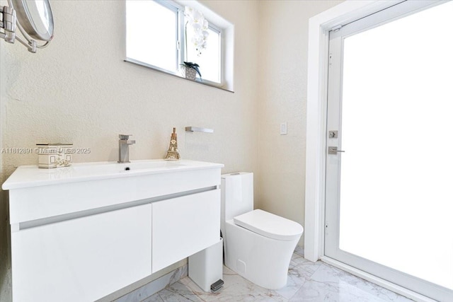 8902 NW 148th St, Miami Lakes, FL 33018 - bathroom with marble finish floors, toilet, vanity, and a textured wall