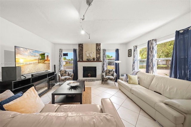 504 SW 5th Ave, Hallandale Beach, FL 33009 - living area featuring light tile patterned floors, rail lighting, a brick fireplace, a textured ceiling, and plenty of natural light