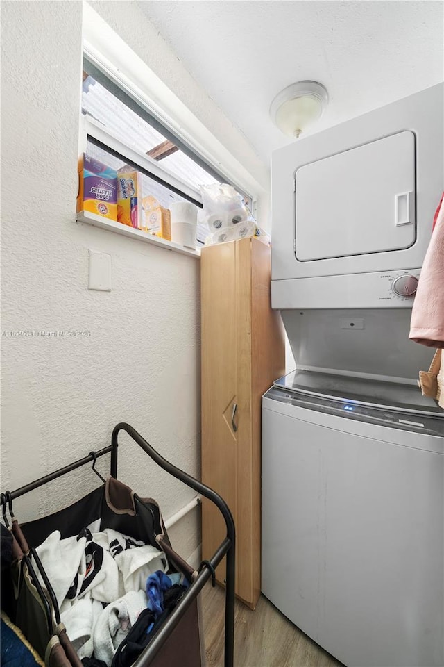 504 SW 5th Ave, Hallandale Beach, FL 33009 - laundry area with stacked washer and clothes dryer, light wood finished floors, and a textured wall