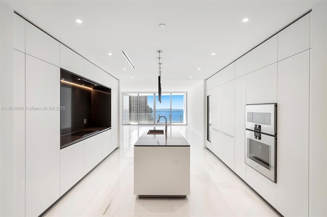300 Biscayne Boulevard Way Unit 1904C, Miami, FL 33131 - kitchen featuring modern cabinets, an island with sink, white cabinets, a sink, and double oven