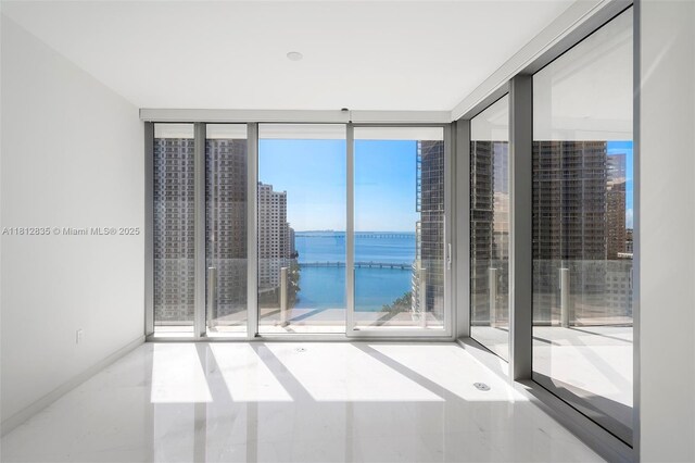 300 Biscayne Boulevard Way Unit 1904C, Miami, FL 33131 - empty room featuring a water view, healthy amount of natural light, expansive windows, and baseboards