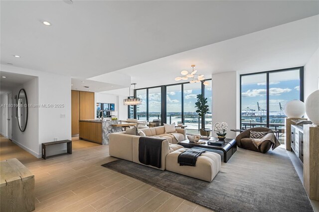 500 Alton Rd Unit 1603, Miami Beach, FL 33139 - living area featuring light wood finished floors, a wall of windows, and a chandelier