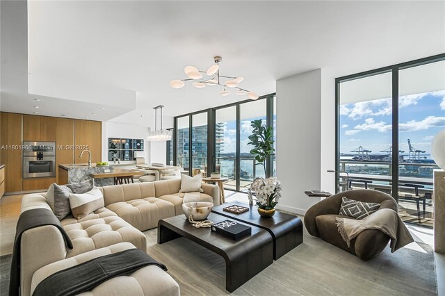500 Alton Rd Unit 1603, Miami Beach, FL 33139 - living room featuring floor to ceiling windows, a chandelier, and light wood-style floors