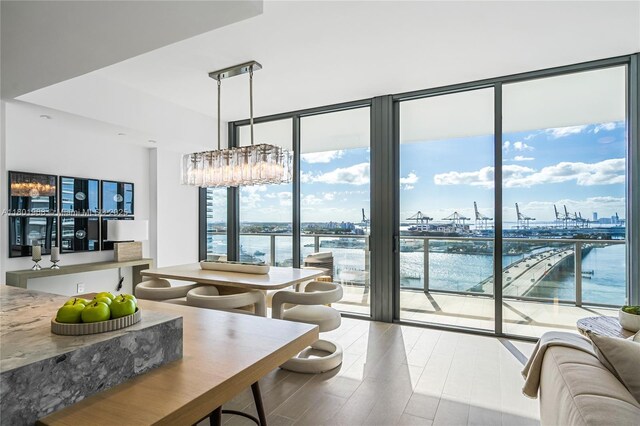 500 Alton Rd Unit 1603, Miami Beach, FL 33139 - dining room featuring floor to ceiling windows, a chandelier, a water view, and wood finished floors