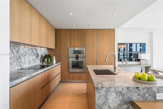 500 Alton Rd Unit 1603, Miami Beach, FL 33139 - kitchen with a sink, black electric stovetop, light stone countertops, modern cabinets, and recessed lighting
