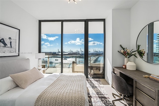 500 Alton Rd Unit 1603, Miami Beach, FL 33139 - bedroom featuring floor to ceiling windows, a water view, light wood-style floors, an office area, and access to exterior